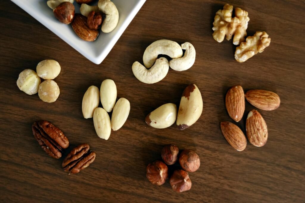 A variety of nuts and dry fruits like almonds, walnuts, and cashews spread on a table, representing the best Ayurvedic foods for winter warmth and energy.