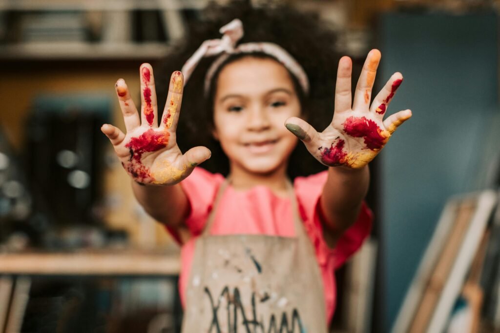 A young child happily painting with vibrant colors, representing a joyful morning activity
